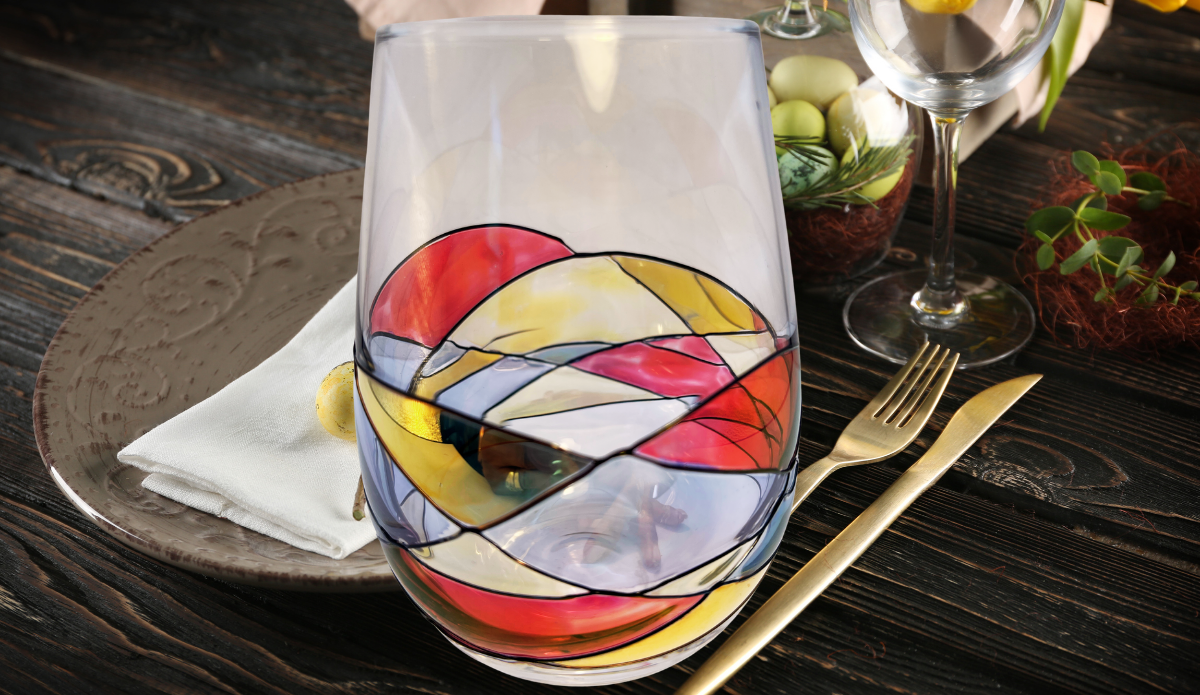 Hand Painted Mosaic Stemless Wine Glass displayed on an elegant dining table with place settings