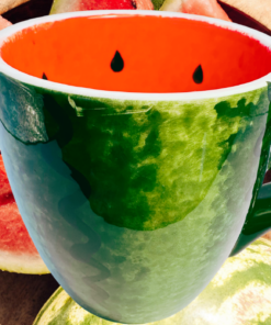 Realistic Hand Painted Watermelon Coffee Mug displayed with fresh watermelon slices on a wooden serving tray in a bright summer setting.