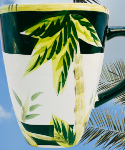 Lahaina II Palm Tree Mug displayed with tropical palm trees at sunset