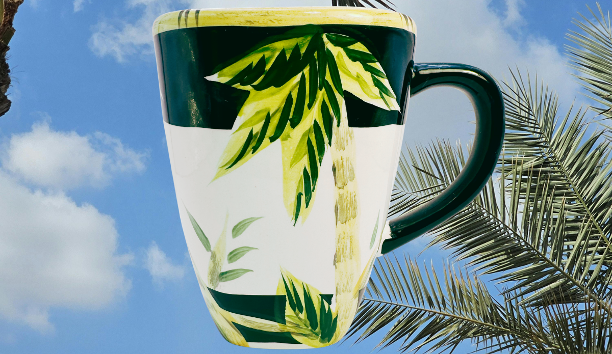 Lahaina II Palm Tree Mug displayed with tropical palm trees at sunset