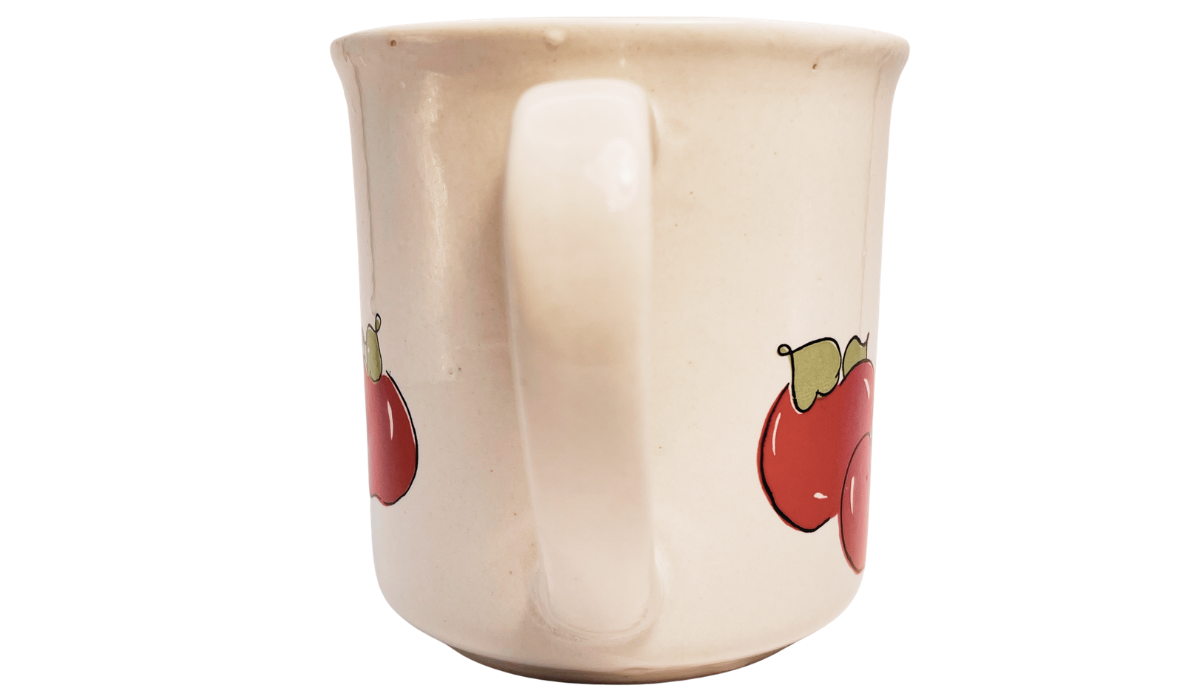 Nancy Lynn Plums and Cherries Mug handle view with centered cream-white handle and partial red fruit artwork on both sides.