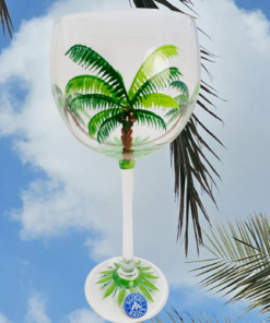 Block Basics Palm Breeze hand painted wine glass displayed beneath tropical palm trees