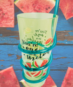 You’re One In A Melon Swirly Straw Acrylic Tumbler displayed among fresh watermelon wedges on a rustic blue wooden surface.