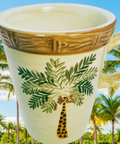Home Trends West Palm Palm Tree Mug displayed against a sunny tropical palm grove with lush green palm trees and bright blue skies