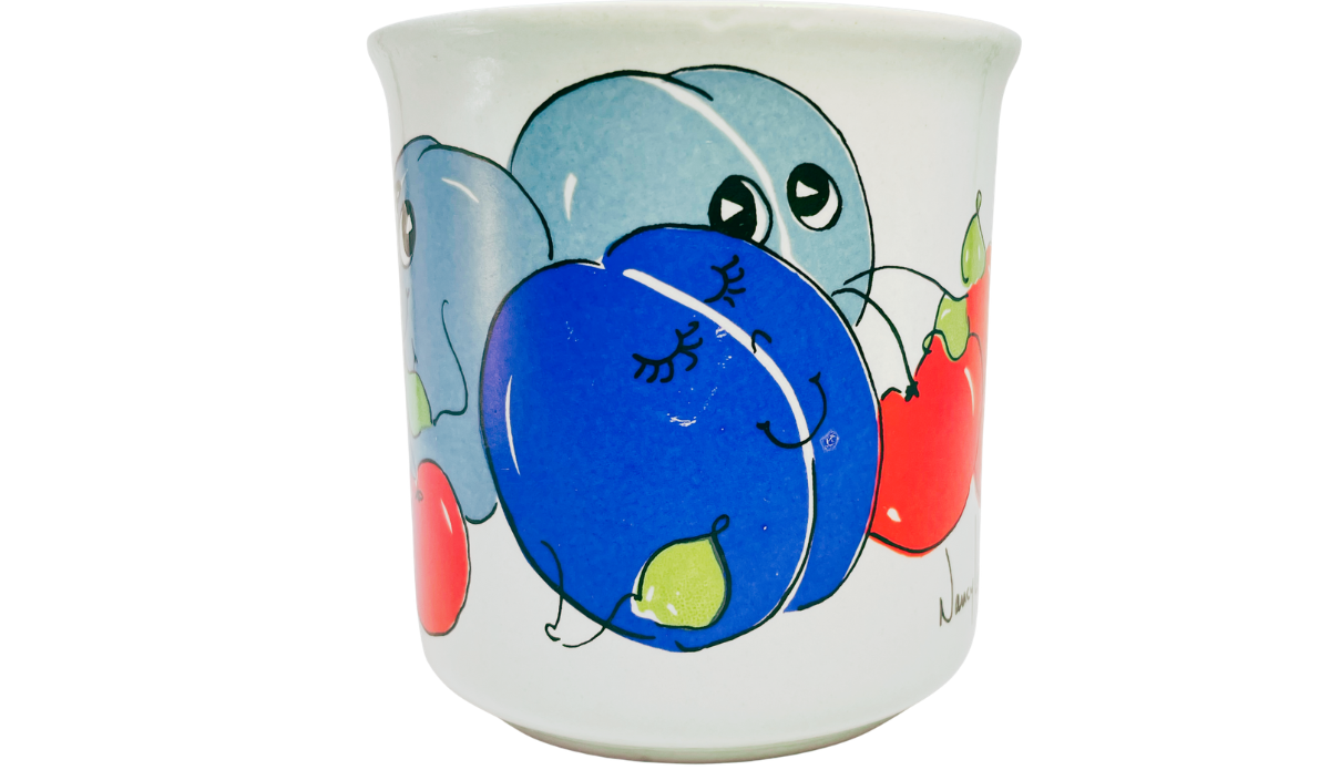 Nancy Lynn Plums and Cherries Mug middle view with white handle, smiling blue plum, red cherries, and partial artist mark.