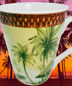 Godinger Tropical Palm Tree Porcelain Mug displayed against a tropical sunset with palm trees