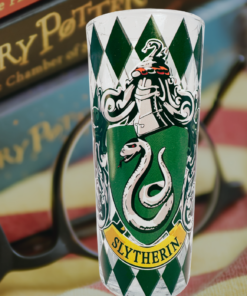 Harry Potter Slytherin House Crest Glass displayed with Harry Potter books, reading glasses, and a striped blanket