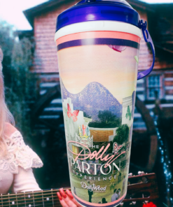 Dollywood Dolly Parton Experience souvenir tumbler in a country music inspired lifestyle scene with guitar and rustic backdrop