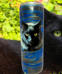 Black Cat Tumbler lifestyle scene with black cat and bright green eyes in garden setting