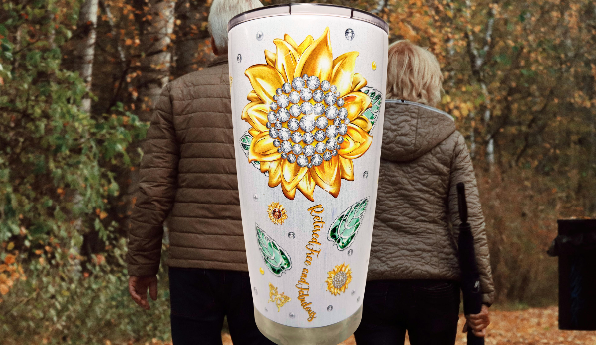 Happy Retirement Tumbler lifestyle scene with sunflower artwork and retired couple walking outdoors