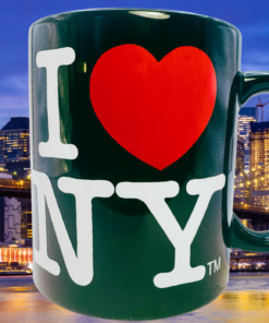 City Merchandise I Love New York Black Mug displayed against the Brooklyn Bridge and illuminated Manhattan skyline