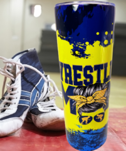 Wrestling Mom Tumbler lifestyle scene beside wrestling shoes in a gym setting