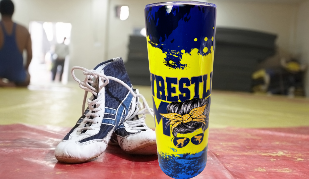 Wrestling Mom Tumbler lifestyle scene beside wrestling shoes in a gym setting