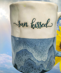Sun Kissed Blue Drip Glaze Mug displayed with sunflower sunlight and bright blue sky