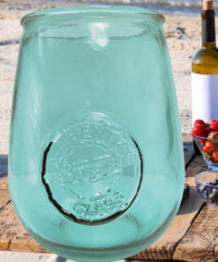 San Miguel teal recycled glass stemless wine glass at a beach picnic with wine berries and ocean backdrop