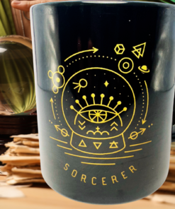 Sorcerer Crystal Ball Coffee Mug displayed with crystal ball and mystical fortune-telling accessories