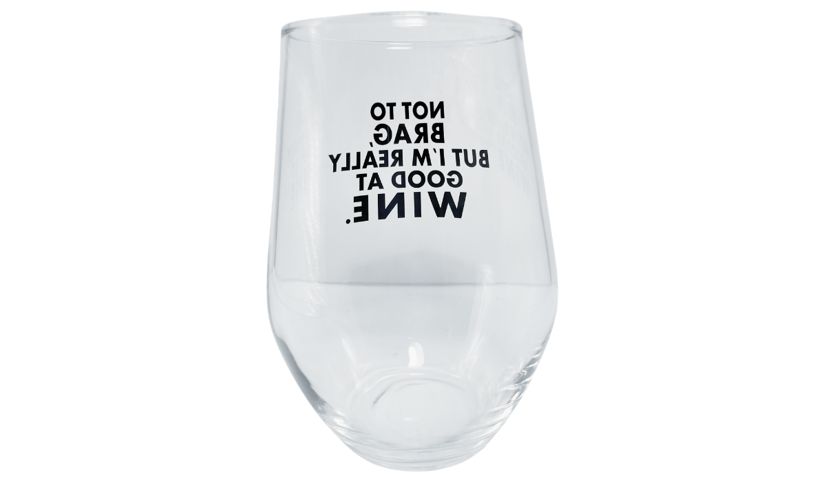Back view of Really Good At Wine Glass with black wording reversed through clear stemless glass