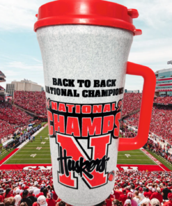 Nebraska Cornhuskers 1994 1995 Champions Travel Mug displayed against a Nebraska football stadium