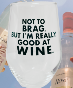 Really Good At Wine Glass displayed between white and rosé wine bottles against blue sky