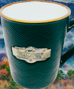 Great Smoky Mountains Medallion Souvenir Mug displayed with misty Great Smoky Mountains autumn foliage