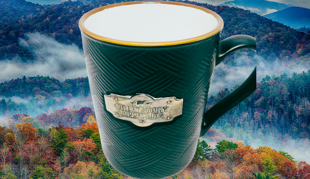 Great Smoky Mountains Medallion Souvenir Mug displayed with misty Great Smoky Mountains autumn foliage