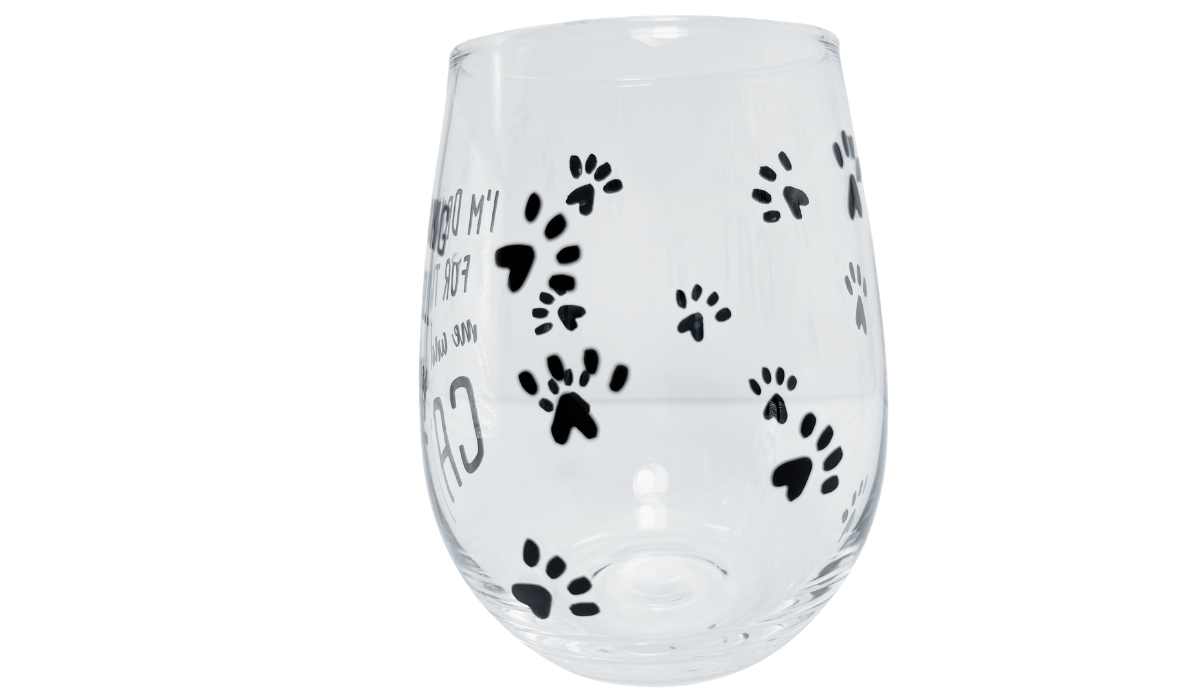 Clear cat stemless wine glass with varied black paw prints and front lettering along the left edge