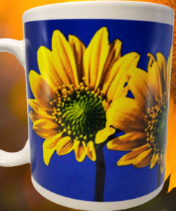 Sunflower Blue Sky Mug displayed with enlarged yellow sunflower imagery and warm golden floral background