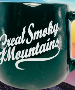 Great Smoky Mountains Black Souvenir Mug displayed with Great Smoky Mountains layered ridges at sunset