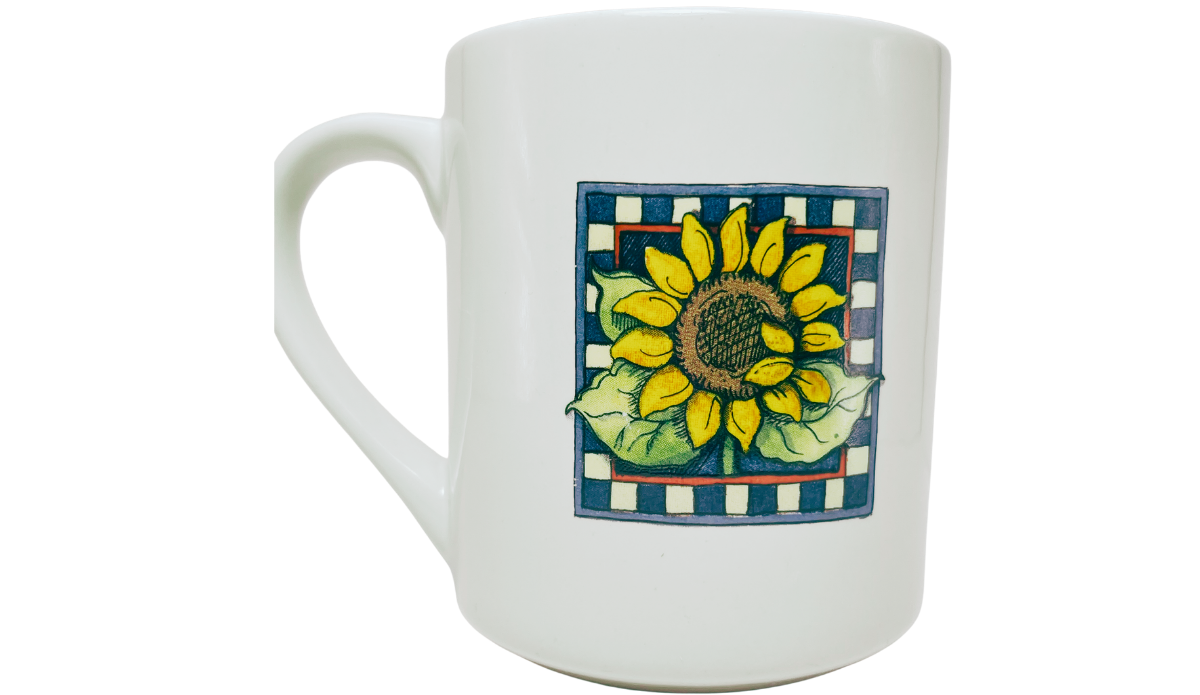Susan Winget Sunflower Coffee Mug front view with yellow sunflower, green leaves, blue checkerboard border, and white handle