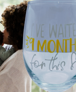 I've Waited 9 Months stemless wine glass beside a mother holding and kissing her baby