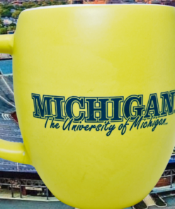 University of Michigan Yellow Mug displayed against a Michigan stadium backdrop
