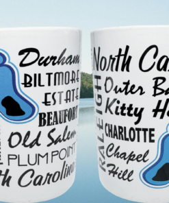 North Carolina Cities Souvenir Mug lifestyle scene with two mug views against a mountain lake and wooded slopes