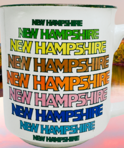 New Hampshire Souvenir Mug displayed against autumn foliage and calm water in New Hampshire