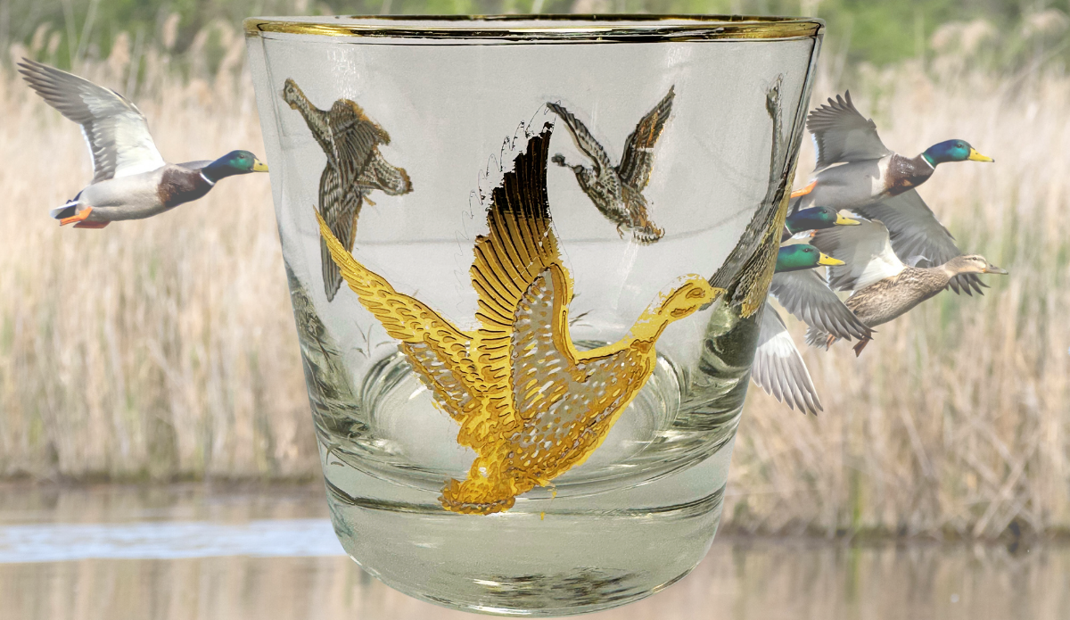 Vintage Game Bird Whiskey Glass displayed in a marsh scene with flying ducks