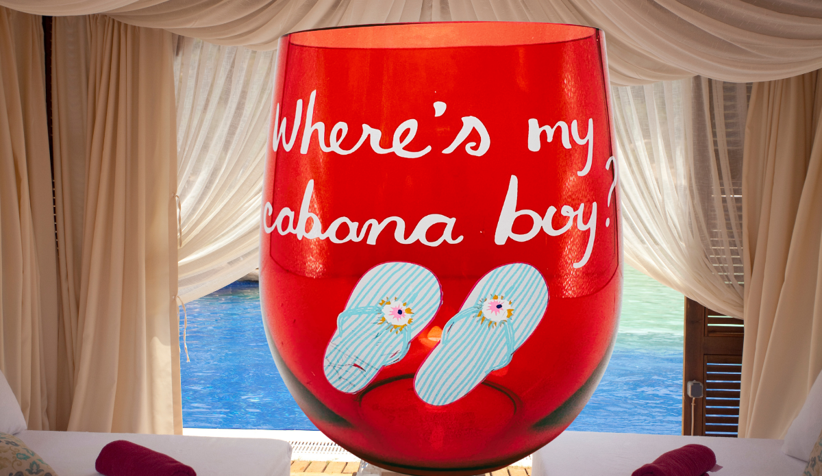 Cabana Boy Acrylic Wine Glass displayed in a tropical poolside cabana setting