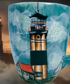 Sakura By The Sea Lighthouse Mug displayed with dramatic lighthouse ocean scene
