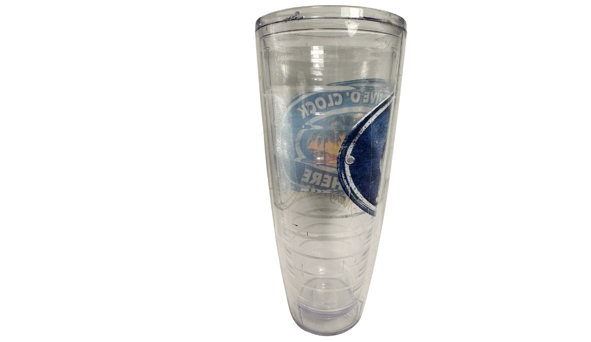 Left side view of Margaritaville sunset tumbler revealing the curved navy-blue graphic and reversed tropical lettering through its transparent body.