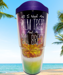 Tervis Palm Trees Cool Breeze Tumbler With purple lid displayed against a sunny tropical beach with turquoise ocean, sand, and tall palm trees.