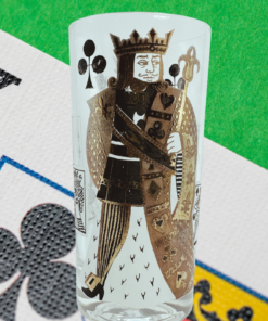 King of Clubs Playing Card Highball Glass displayed on a bright green gaming surface beside an oversized king-of-clubs playing card.
