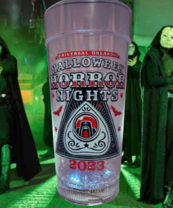 Halloween Horror Nights 2023 Light Up Cup displayed in a green lit spooky Universal Orlando inspired scene
