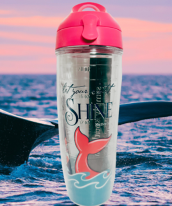 Tervis Simply Southern Let Your Light Shine Water Bottle displayed against an ocean sunset with a whale tail, pink sky and blue waves.
