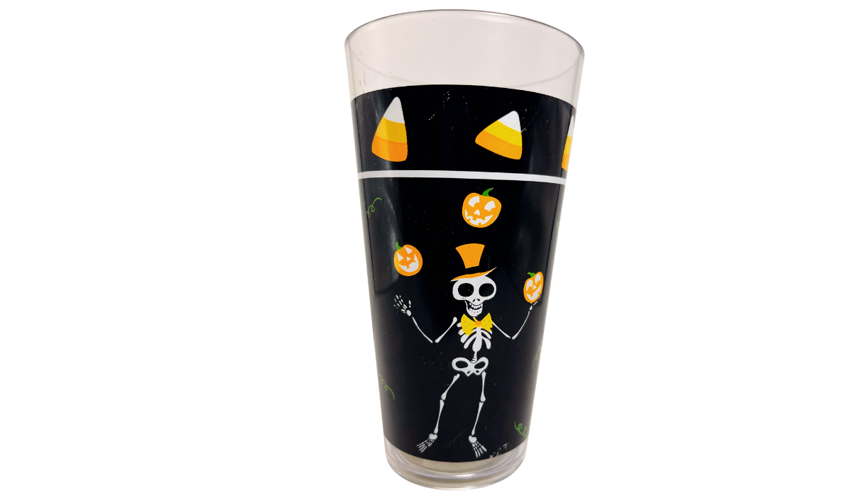 Juggling Skeleton Halloween Acrylic Tumbler with skeleton juggling orange jack-o'-lanterns beneath a candy corn border