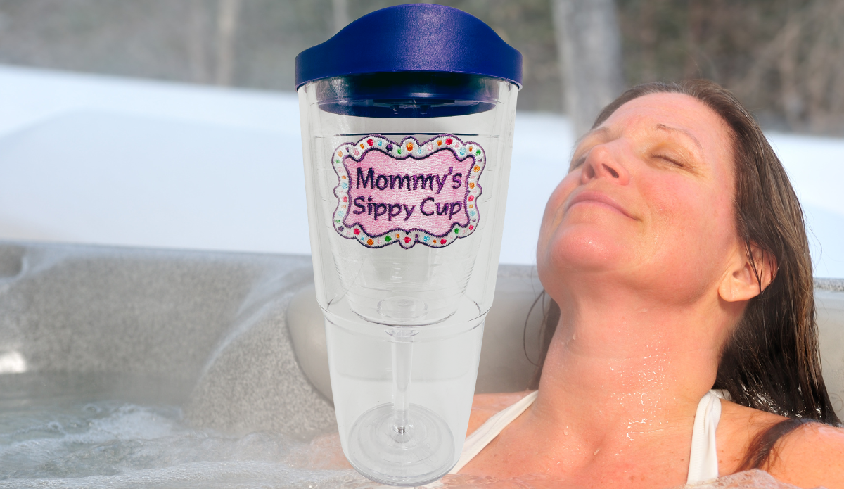 Tervis Mommy's Sippy Cup Tumbler With Lid displayed beside a woman relaxing in an outdoor hot tub, with pink emblem and purple travel lid.