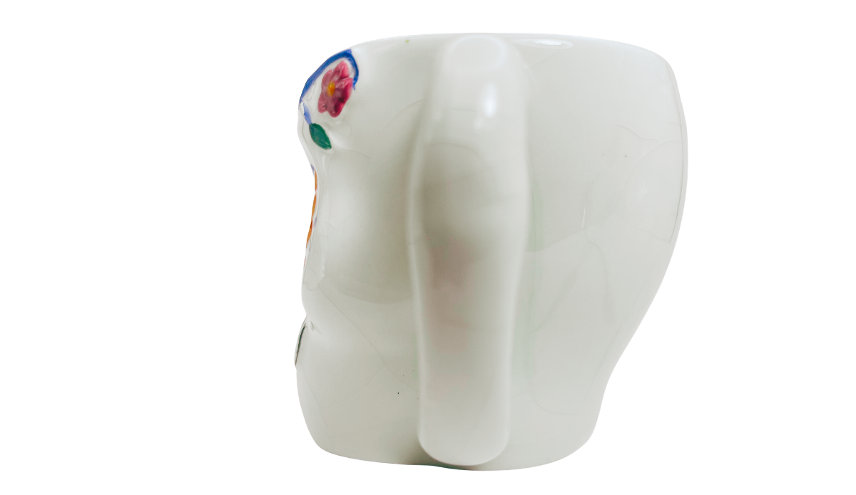 Right side view of Floral Sugar Skull Mug showing sculpted skull shape, white body, and partial floral artwork