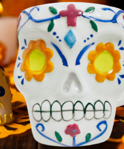 Floral Sugar Skull Mug displayed with marigold flowers, candlelight, and colorful Día de los Muertos decorations