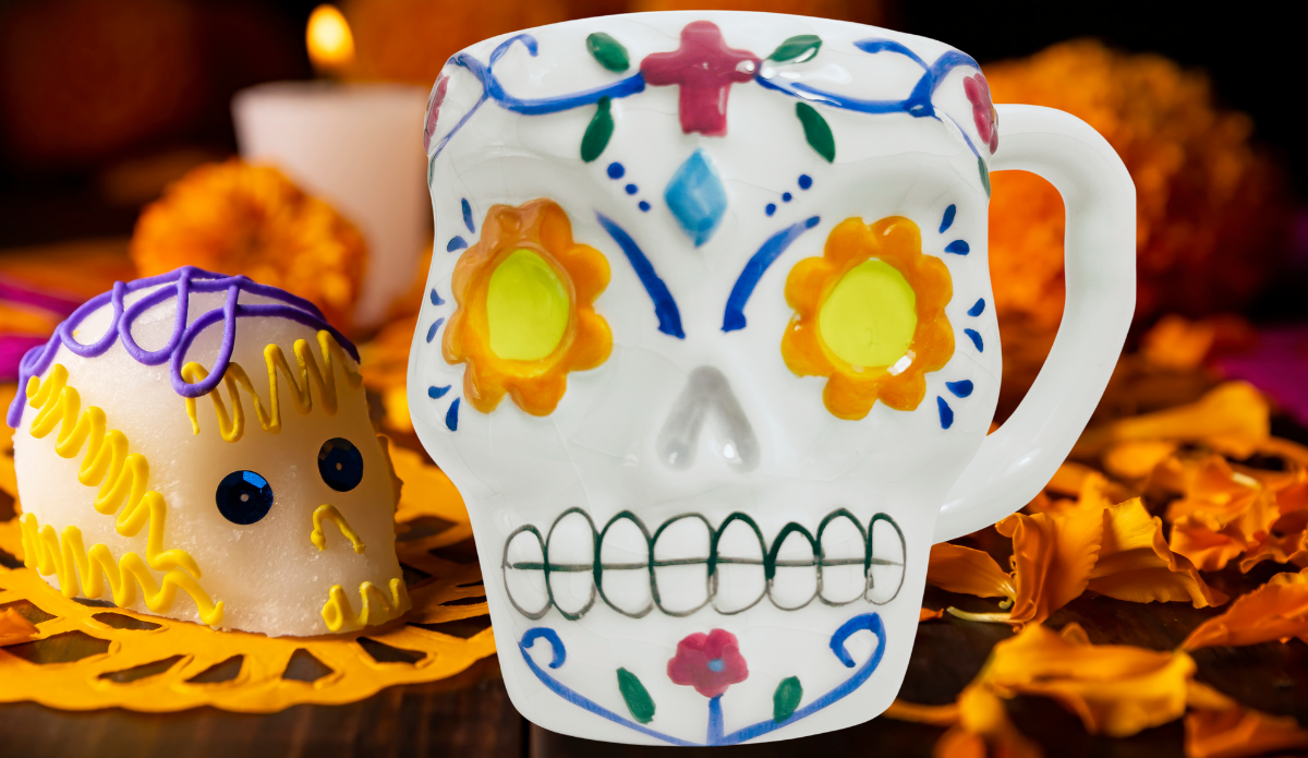 Floral Sugar Skull Mug displayed with marigold flowers, candlelight, and colorful Día de los Muertos decorations