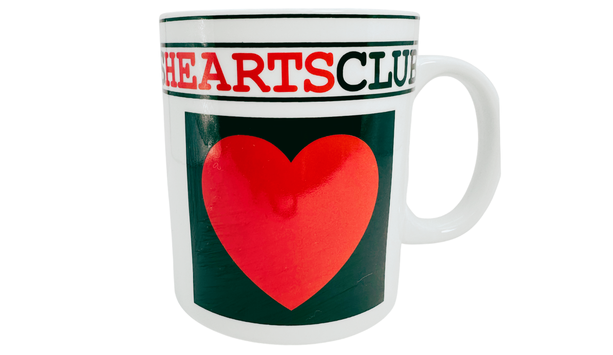 Hearts Playing Cards Coffee Mug front view showing a large red heart on a dark green panel, card suit lettering, and a white ceramic handle.