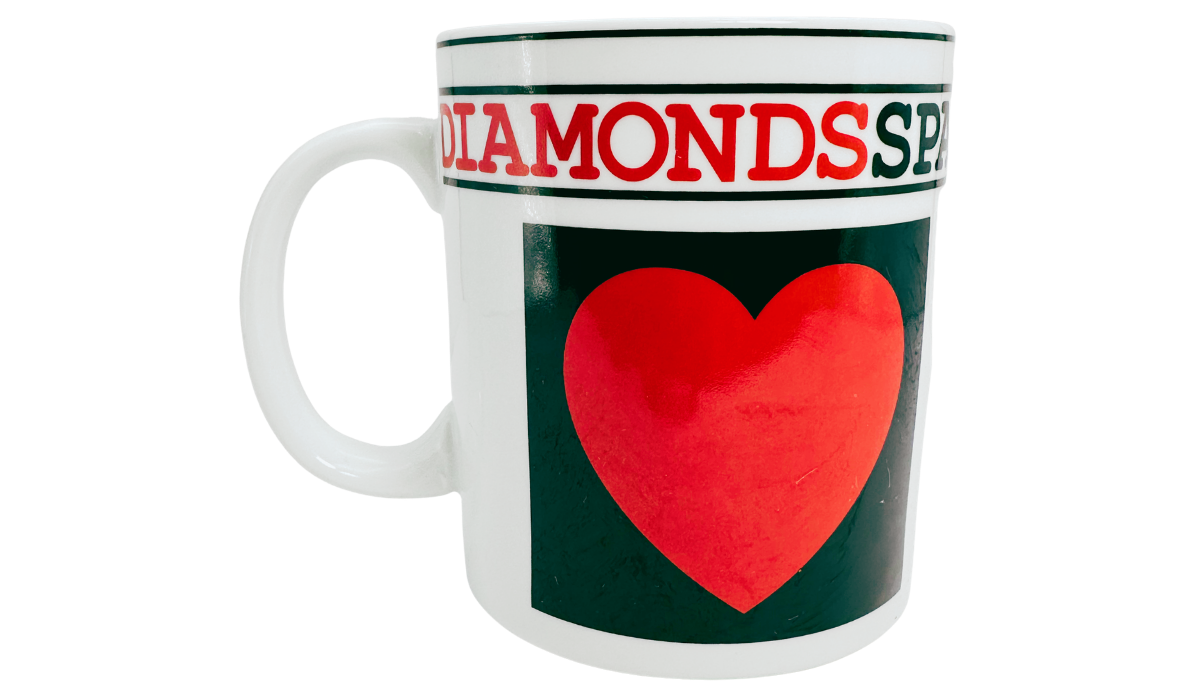 Hearts Playing Cards Coffee Mug back view featuring a large red heart on a dark green panel, Diamonds and Spades lettering, and a white handle on the left.