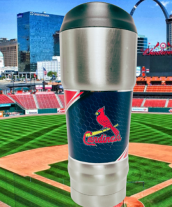 St. Louis Cardinals stainless steel travel tumbler displayed against Busch Stadium with baseball field, St. Louis skyline and Gateway Arch.