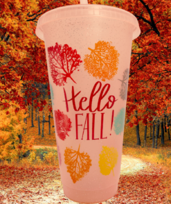Hello Fall Autumn Leaves Tumbler displayed on a path surrounded by vivid orange and red fall foliage